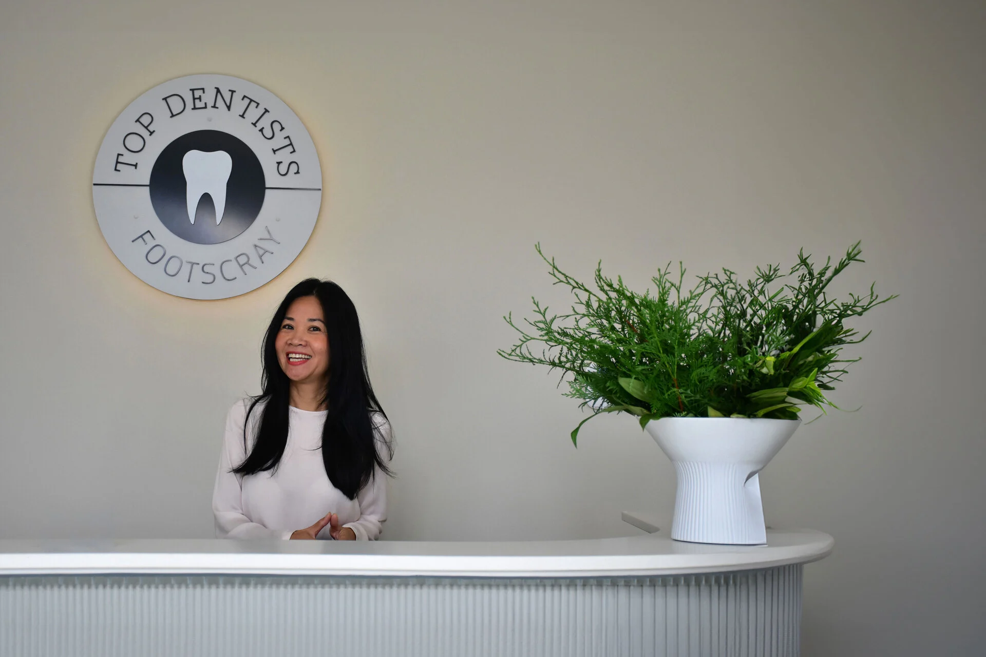 Smiling receptionist welcoming patients at Top Dentists Footscray dental clinic.